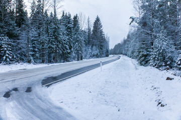 Fototapeta premium Snowy road in winter forest. Beautiful frosty white landscape.