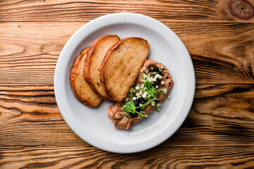 Delicious chicken, duck, or rabbit liver pate or foie gras with spices. fried toast and pate with microgreens