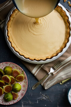 Pouring mascarpone filling in tart shell.
