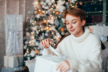 Beautiful teen girl in Christmas decorations on the couch