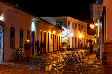 Fototapeta na wymiar Night view of the city of Paraty with its old colonial style houses and the brightness and colors of the city lights reflected in the cobbled streets