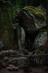 A cave in a crevice of a granite rock overgrown with moss and lichen