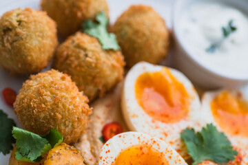 Plate with falafel, soft-boiled egg and yogurt sauce. Fresh food for breakfast