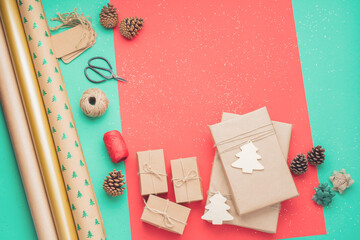 Zero waste eco friendly Christmas. Top view of presents wrapped in brown craft paper, pinecones, on green and red background, copy space, selective focus