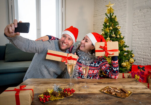 Happy couple on mobile phone video calling friends and celebrating Virtual christmas online