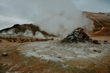 Boiling mudpots in the geothermal area Hverir and cracked ground around, Iceland in summer. Myvatn region, North part of Iceland