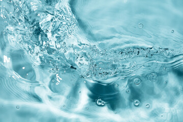 Splash of water flow with bubbles and ripples. Blue water texture. Selective focus. Motion blur