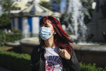 Selective focus shot of an attractive female wearing a facial mask - concept of new normal