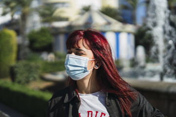 Selective focus shot of an attractive female wearing a facial mask - concept of new normal