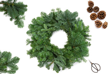 Festive composition, green Christmas wreath made of natural fir branches, ready to be decorated, top view, selective focus, white background