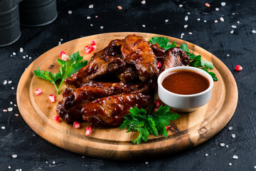 grilled chicken wings on a round wooden Board