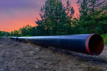 Construction Gas Pipeline Project on amazing sunset background. Natural Gas and Crude oil Transmission in pipe to LNG plant (shipped by LPG tanker). Building of transit petrochemical pipe