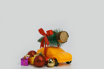 Christmas tree with the bow tie on toy yellow car. Christmas  festival holiday celebration concept