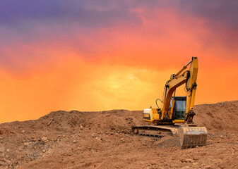 Excavator working on earthmoving at open pit mining on amazing sunset background. Backhoe digs sand...
