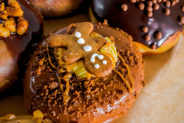 Selective focus on sophisticated donut with praline, sweet cream, caramel topping and gingerbread man