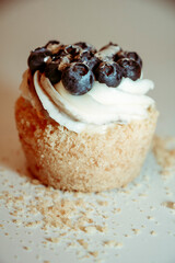 
Cupcake with cream and blueberries on white background