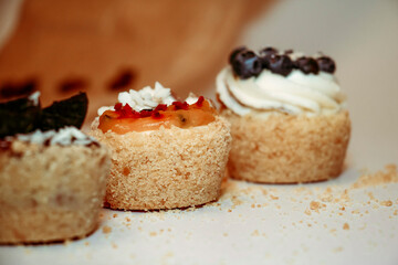 
Different types of muffins with cream and fillings on a white background