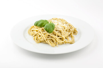 Homemade carbonara served on a white pate, topped with basil leafs and grated parmesan. Studio photo isolated on white background.