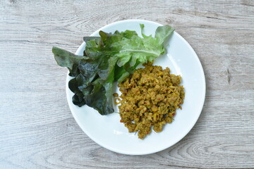 spicy stir fried chop pork with yellow turmeric curry eat couple red oak Thai southern food on dish