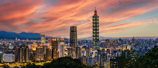 Fototapeta premium View from above, stunning view of the Taipei City skyline illuminated during a beautiful sunset. Panoramic view from the Mount Elephant in Taipei, Taiwan.