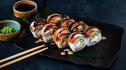 making the sushi with sauce and sesame seeds