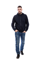 Serious young man in jeans and a hoodie walks forward. Full height. Isolated on white background. Vertical.