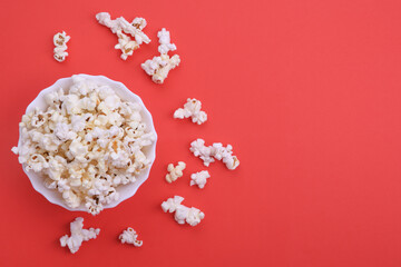 Popcorn in bowl on a red background. Close up. Top view