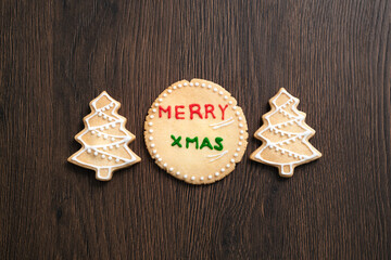 Top view of decorated Christmas tree cookie on wooden table background with copy space.