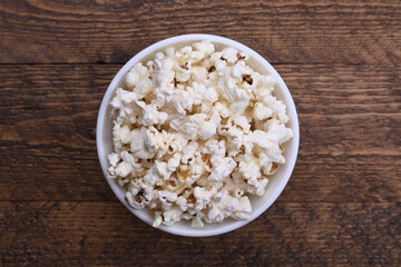 Popcorn in bowl on a red background. Close up. Top view