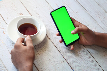  rear view of man hand using smart phone on table 
