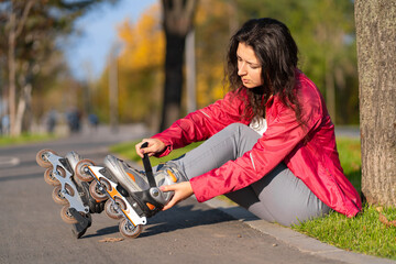 Active leisure. A sportive girl is rollerblading in an autumn park