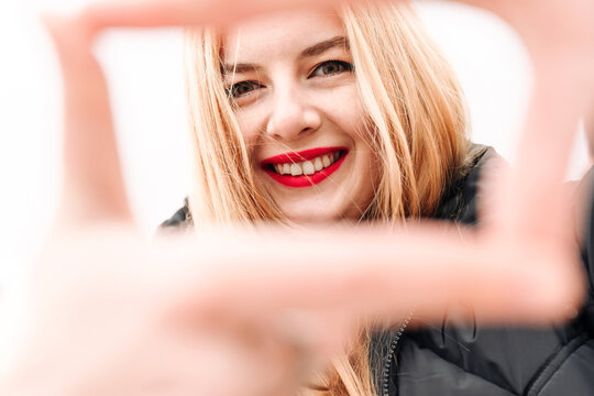 Young beautiful carefree woman smiling making frame with hands and fingers with happy face. Creativity and photography concept