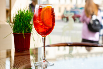 Traditional Spritz aperitif in a bar in Italy, glass of cocktail Aperol Spritz on table terrace of restaurant