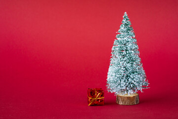 Christmas holiday background. Snow-covered Christmas tree and bright multi-colored boxes with gifts. Copy space
