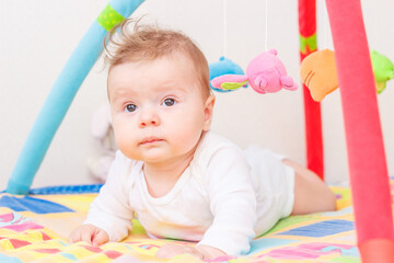 Playing child on the colored mat for developing, soft focus background