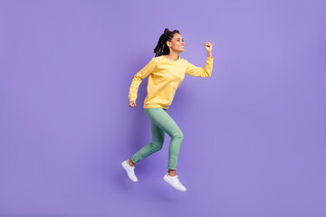 Fototapeta na wymiar Full size profile photo of optimistic girl jump wear yellow shirt trousers sneakers isolated on lilac color background