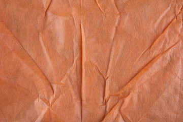 Orange wavy fabric texture background. Copy space.