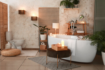 Interior of modern bathroom with burning candles in evening