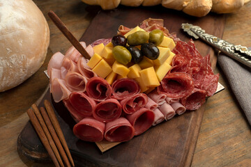 table of cold cuts and various cheeses with olives, homemade bread chopped with loin, ham, bondiola, bacon, salami, and a variety of cheeses