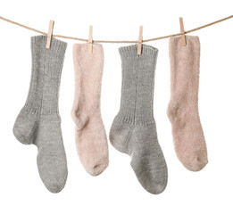 Warm socks hanging on clothes line against white background