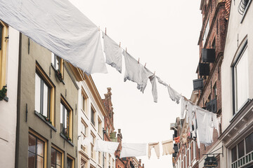 White laundry attached to a laundry line above the street