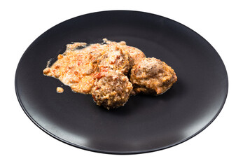 portion of meatballs with rice with creamy tomato sauce on black plate isolated on white background
