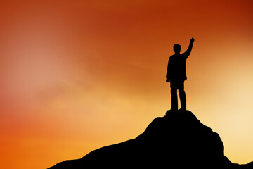 Silhouette of Businessman stand on the top of hill , achievement , success and leadership concept.