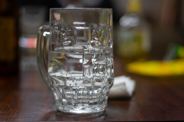 Beer glass with water. The drink is on the table. 