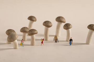 Composition of miniature people figurines among mushroom decorations