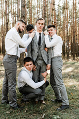 handsome groom hugs with cheerful friends, wedding day of newlyweds, young friends, funny company of people, holiday in the family,funny friends,world wedding