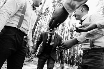friends lift a happy groom on their shoulders, a group of friends laughs and have fun, happy people,handsome groom with lovely friends smiling