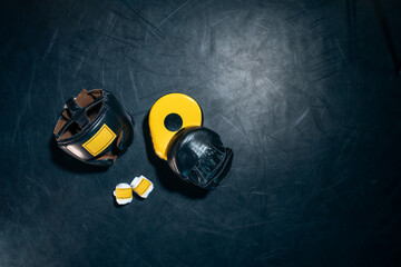 top view of boxing paws, helmet and bandage tape on black background