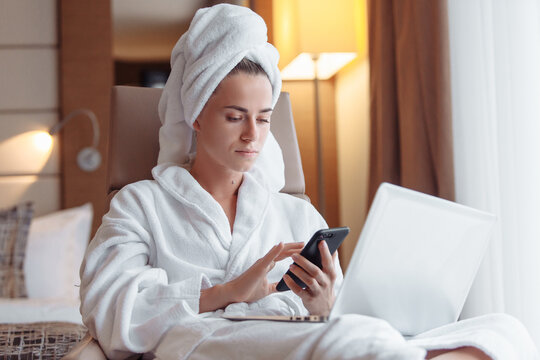 European young female model texting message on phone uses modern convenient messenger. Busy girl solves problem remotely by business using Internet. High-tech Gadgets for successful people on vacation