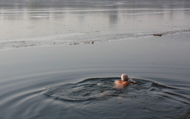 Man swimming in iced lake in China in Winter